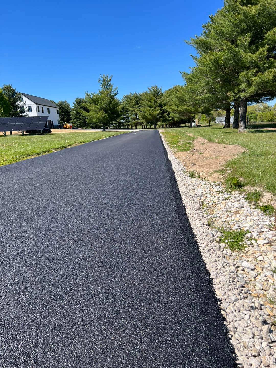 Long paved driveway with stone border